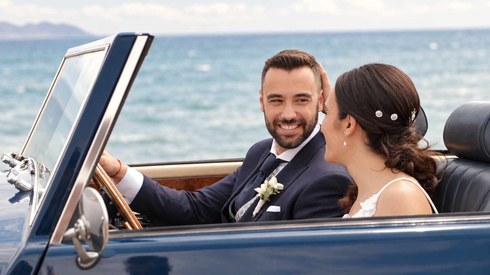 Diana y José Juan sonríen dentro del coche junto al mar